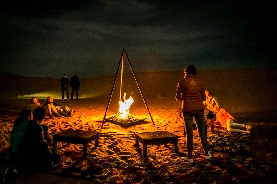 Camping au camp berbère au milieu des dunes de l'erg chebbi autour du feu et de la musique berbère lors de votre voyage de 4 jours dans le désert